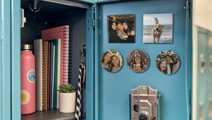 Custom photo magnets inside a blue school locker door, with a water bottle, notebooks and a small plant
