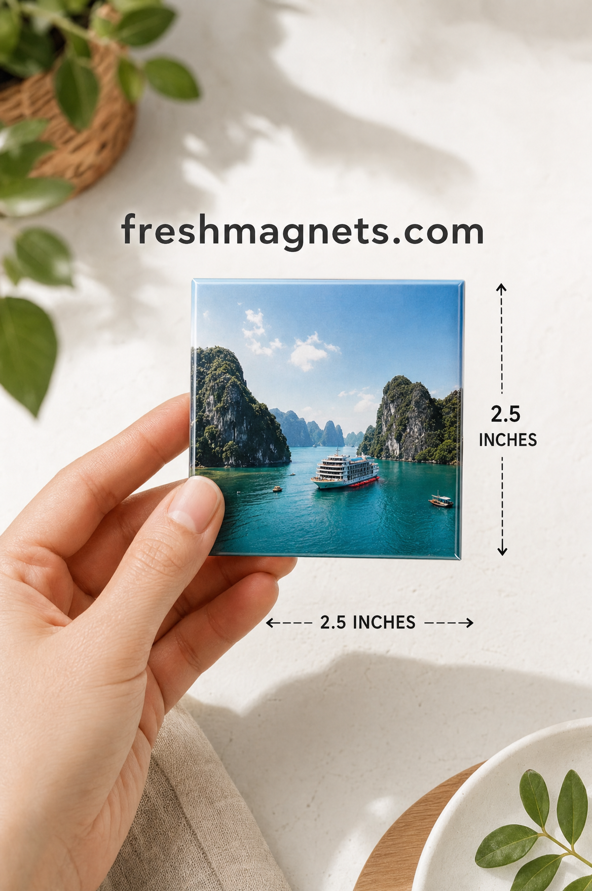 A 2.5 inch square photo magnet held in a hand with the 2.5 inch width and height marked, freshmagnets.com